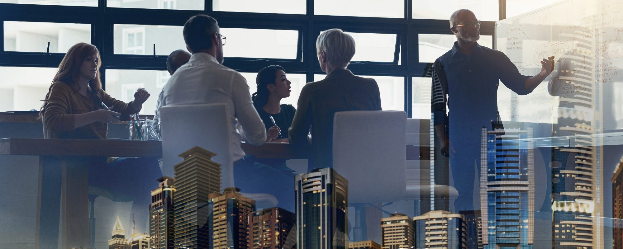 Full length shot of a mature businessman giving a presentation in the boardroom superimposed over a city